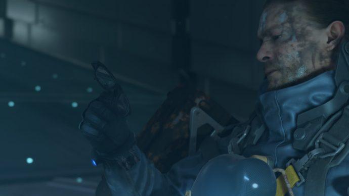 Sam is holding Gordon Freeman's glasses after getting the first cube in Death Stranding.