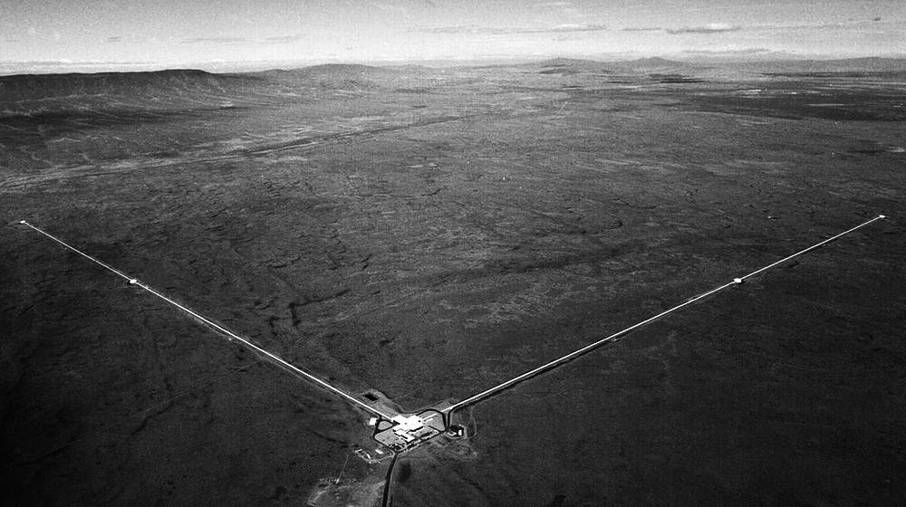 Детектор LIGO в г. Хэнфорде, штат Вашингтон, имеет две длинные стрелы, расположенные под прямым углом. Лазеры внутри каждой стрелы измеряют относительную разницу длин каждой из стрел при прохождении гравитационной волны